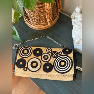 Cole Haan woven straw clutch featuring black patent leather trim